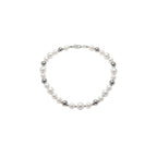 Pearl necklace worn by a person against a plain background