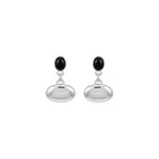 Close-up of a person wearing a silver earring with a black gemstone.