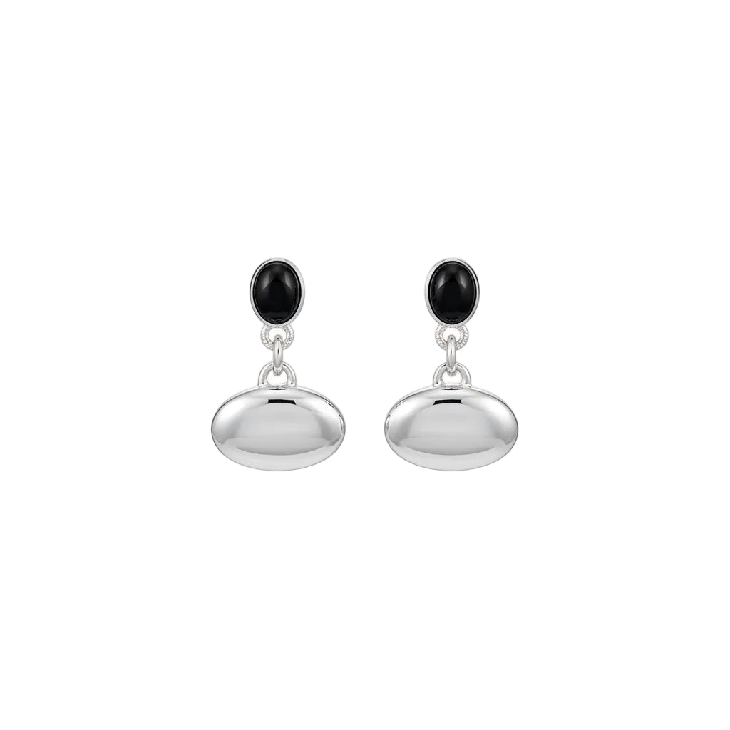 Close-up of a person wearing a silver earring with a black gemstone.