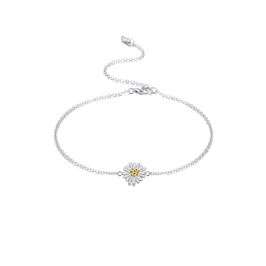 Silver anklet with a daisy charm on a person's ankle against a white background
