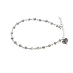 Silver anklet with heart charm on a white background