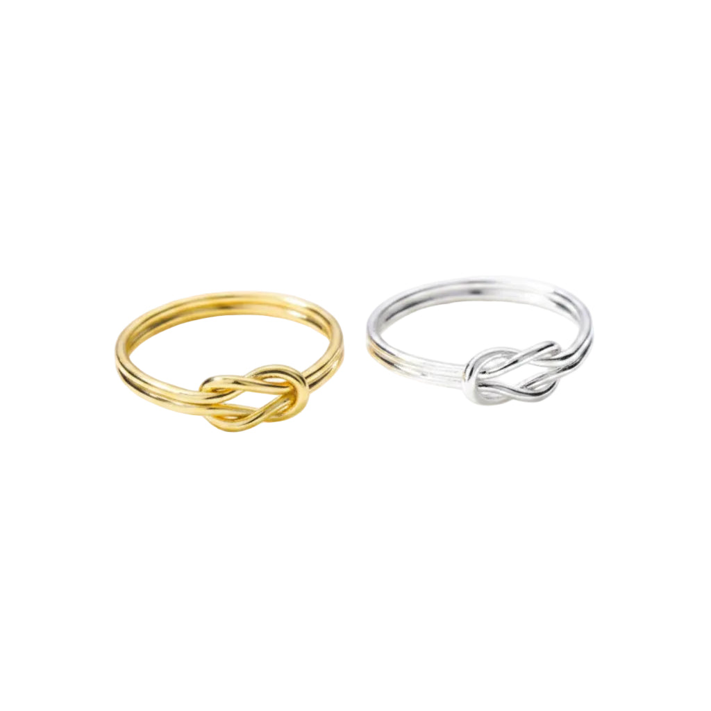 Gold and silver rings on a white surface with blurred text background