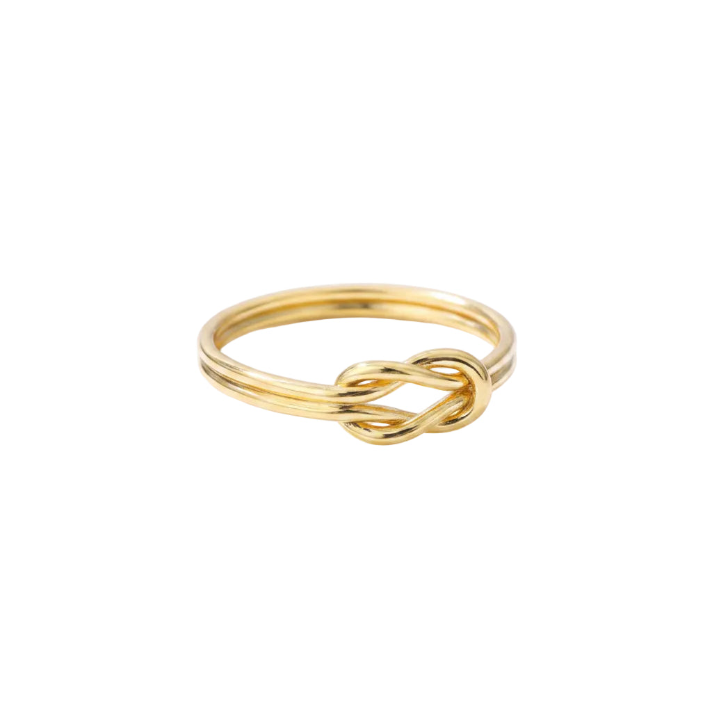 Gold knot ring on a gray cushioned surface